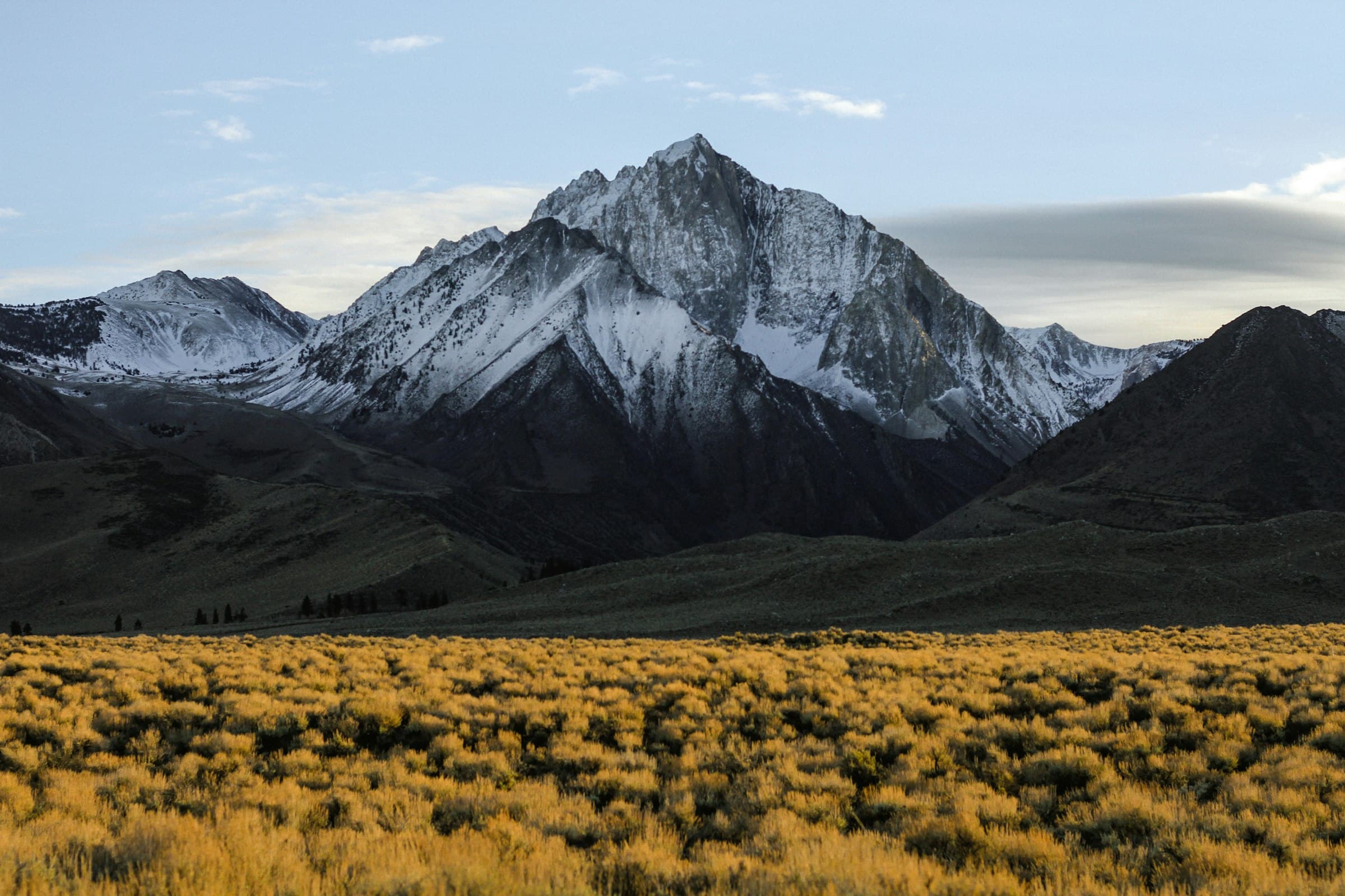 Arid high-desert valley below a snow-capped Himalayan peak