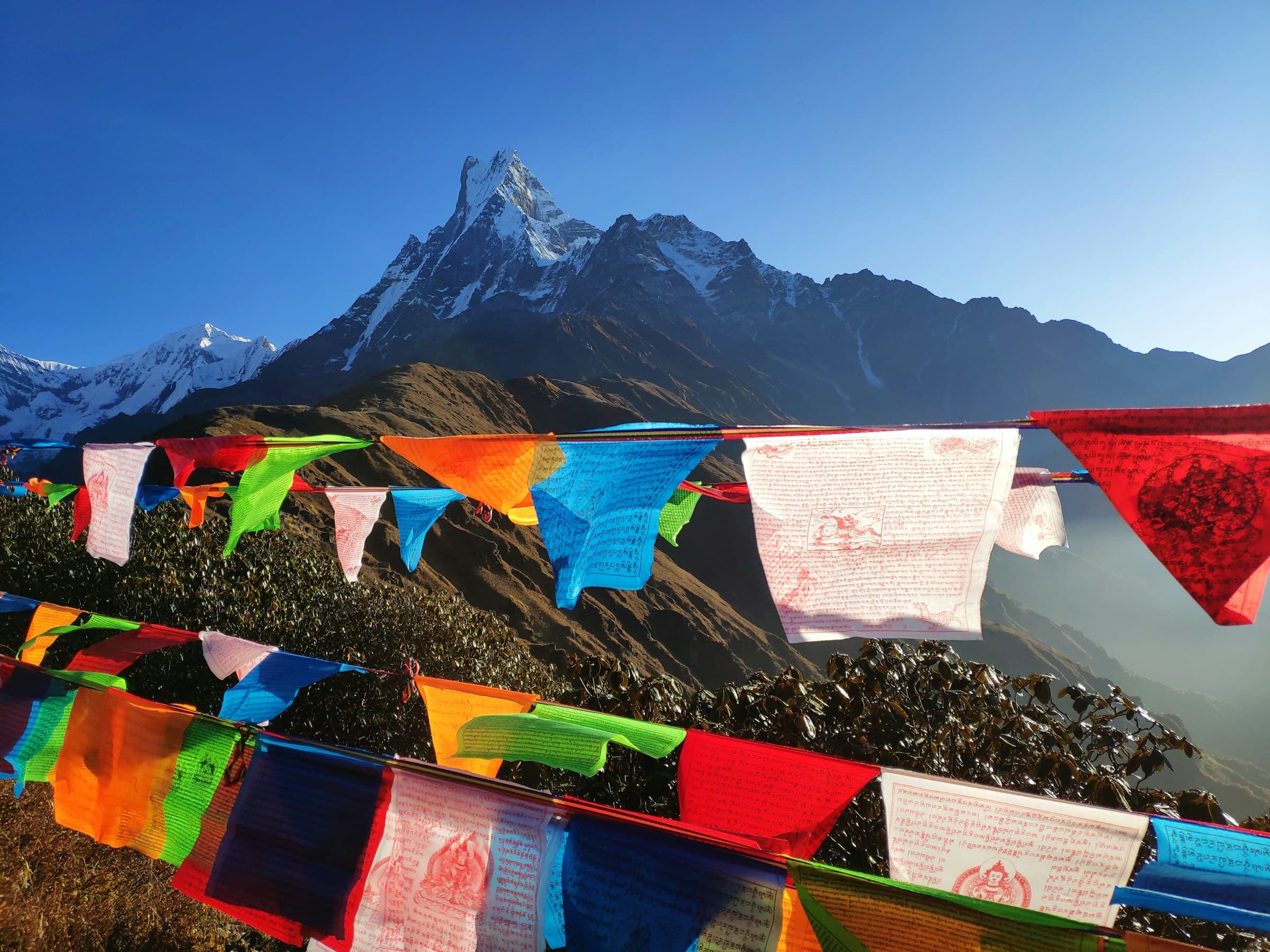 Prayer flags strung before the peak of Machapuchare on the Annapurna trail
